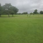 Panoramic view of a lush green golf course at Tinker Golf Course. Smooth