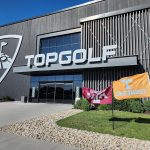 Panoramic view of a lush green golf course at Topgolf. Smooth
