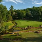 Panoramic view of a lush green golf course at Tot Hill Farm Golf Club. Smooth
