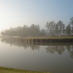 Panoramic view of a lush green golf course at Tour 18 Golf Course. Smooth