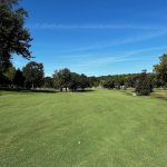 Panoramic view of a lush green golf course at Trails West Golf Course. Smooth