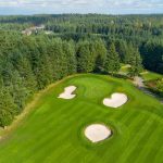Panoramic view of a lush green golf course at Trophy Lake Golf & Casting. Smooth
