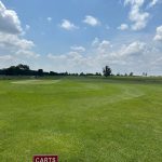 Panoramic view of a lush green golf course at Turkey Creek Golf Course. Smooth