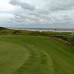 Panoramic view of a lush green golf course at Turtle Point Golf Course. Smooth