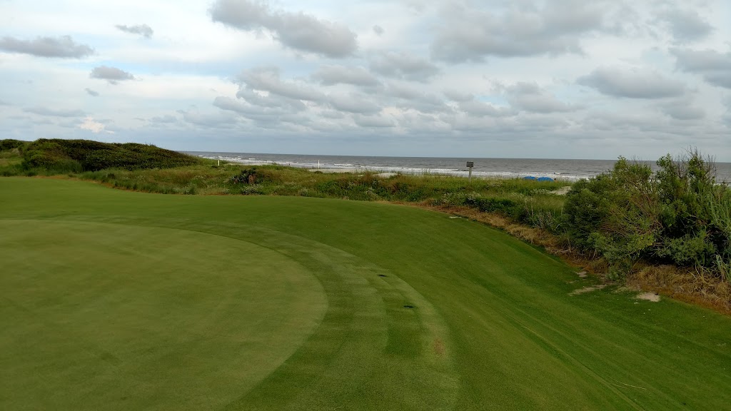 Panoramic view of a lush green golf course at Turtle Point Golf Course. Smooth
