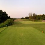 Panoramic view of a lush green golf course at UT Golf Club. Smooth
