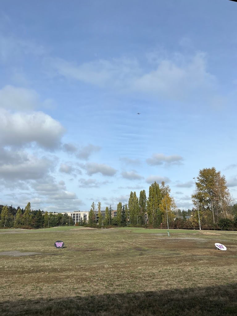 Panoramic view of a lush green golf course at University of Washington Golf Range. Smooth