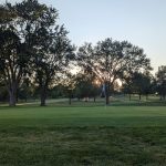 Panoramic view of a lush green golf course at Village Greens Golf Course. Smooth