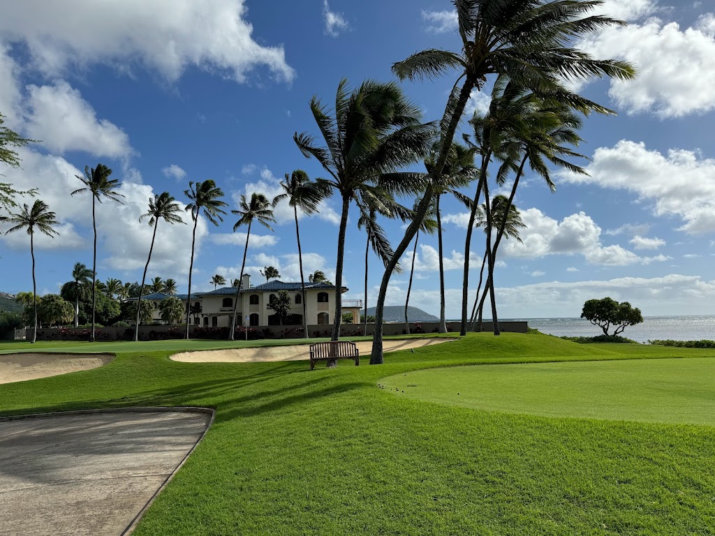 Panoramic view of a lush green golf course at Wai`alae Country Club. Smooth