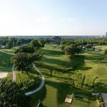 Panoramic view of a lush green golf course at Wakonda Club. Smooth