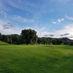 Panoramic view of a lush green golf course at Walsh Golf Center. Smooth
