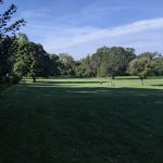 Panoramic view of a lush green golf course at Warren Swigart Golf Course. Smooth