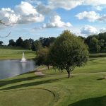 Panoramic view of a lush green golf course at West Liberty Country Club. Smooth