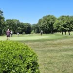 Panoramic view of a lush green golf course at Western Hills Golf Course. Smooth