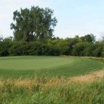 Panoramic view of a lush green golf course at Whetstone Creek Golf Course. Smooth