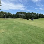 Panoramic view of a lush green golf course at Whispering Pines. Smooth