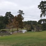 Panoramic view of a lush green golf course at Whispering Pines Golf Club. Smooth