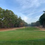 Panoramic view of a lush green golf course at Whispering Pines Golf Course. Smooth