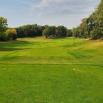 Panoramic view of a lush green golf course at Wild Rock Golf Club. Smooth