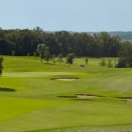 Panoramic view of a lush green golf course at Wildflower Golf Course. Smooth