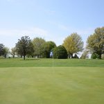 Panoramic view of a lush green golf course at Wildwood Golf Course. Smooth
