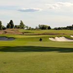 Panoramic view of a lush green golf course at Windsong Farm Golf Club. Smooth