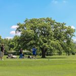 Panoramic view of a lush green golf course at Woodland Hills Golf Course. Smooth