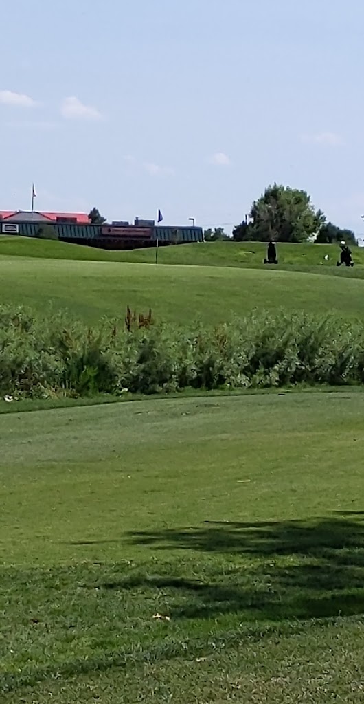 Panoramic view of a lush green golf course at World Golf & Sand Creek Golf Course. Smooth