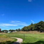 Panoramic view of a lush green golf course at Yale Golf Course. Smooth