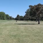 Panoramic view of a lush green golf course at Yankee Springs Golf Course. Smooth
