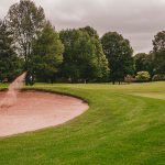 Panoramic view of a lush green golf course at Oxford Greens. Smooth